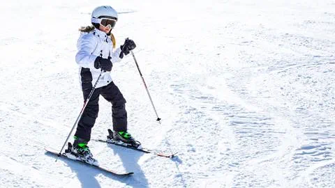 young female skier taking a lesson on a ski slope