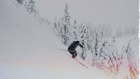 Skier riding powder on a steep slope